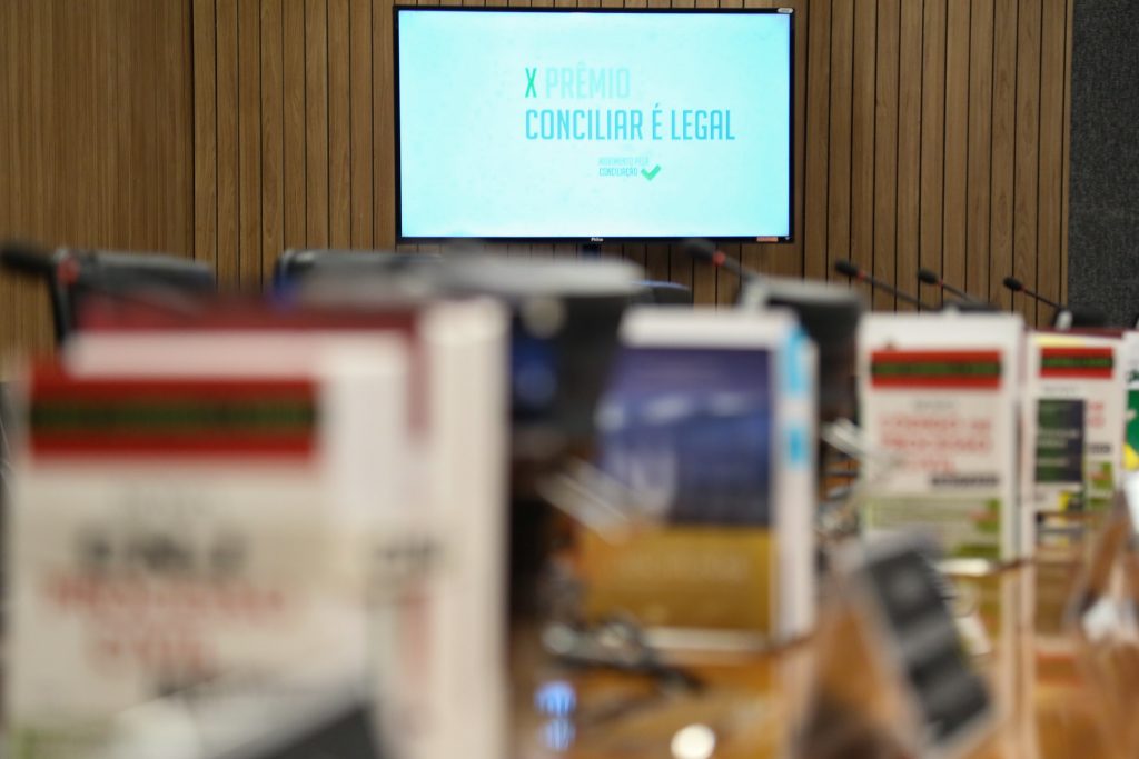 Foto ilustrativa do plenário do CNJ onde ao fundo tem telão escrito 10º Prêmio Conciliar é Legal