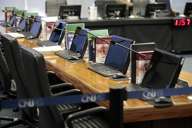 computadores alinhados em bancada do plenário do CNJ
