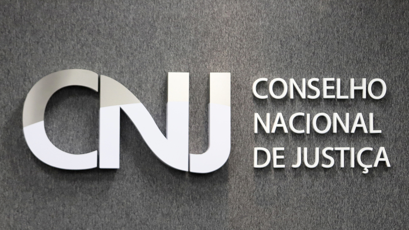 Foto da logomarca do CNJ que fica ao fundo do Plenário do órgão