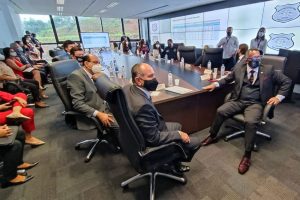 Foto de sala, com grande mesa no centro, e quase 20 pessoas sentadas acompanhando o lançamento da ferramenta.