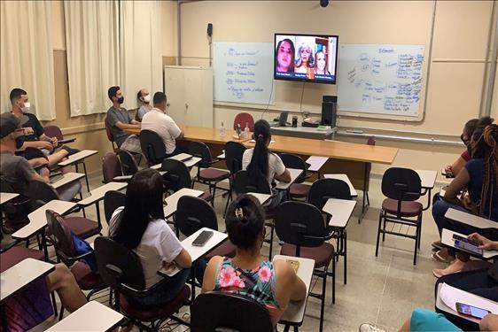 Foto de alunos e alunas em sala de aula acompanhando a live.